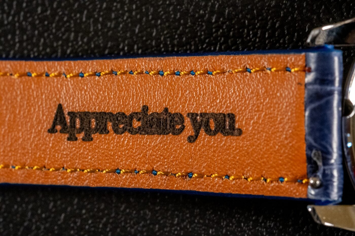 Orange leather watch strap with “Appreciate you.” heat-debossed into the leather