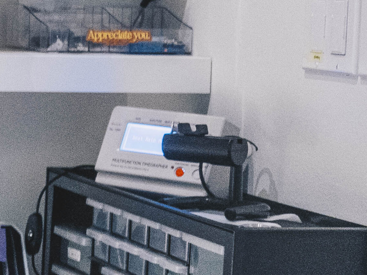 A multifunction timegrapher on the parts drawers with a watch clamped in its microphone holder.